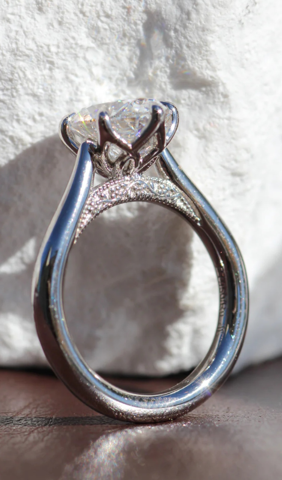 Oval cathedral moissanite engagement ring shown from the side